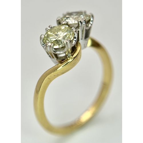 674 - An 18K Yellow Gold Diamond Crossover Ring. A 1ct round brilliant cut diamond having I colour and com... 