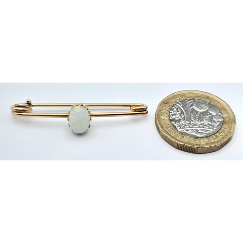 103 - A 9K GOLD BAR BROOCH WITH AN OVAL OPAL STONE .    2.7gms