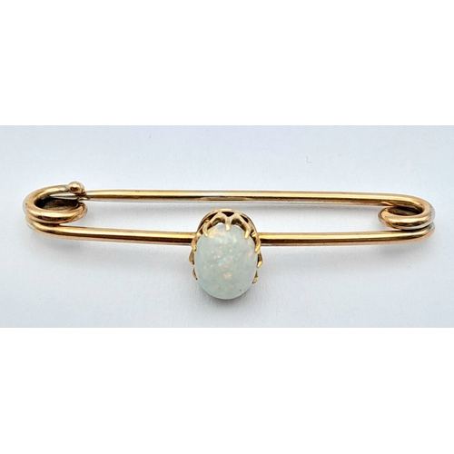 103 - A 9K GOLD BAR BROOCH WITH AN OVAL OPAL STONE .    2.7gms