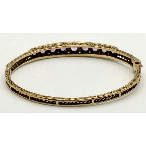 93 - A VINTAGE 9K GOLD HINGED BANGLE WITH DECORATIVE SIDES AND DIAMOND AND AMETHYST TOP STONES .    13.2g... 