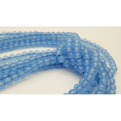 654 - An Aquamarine and Freshwater Pearl Three Strand Scarf Necklace. 123cm strands.