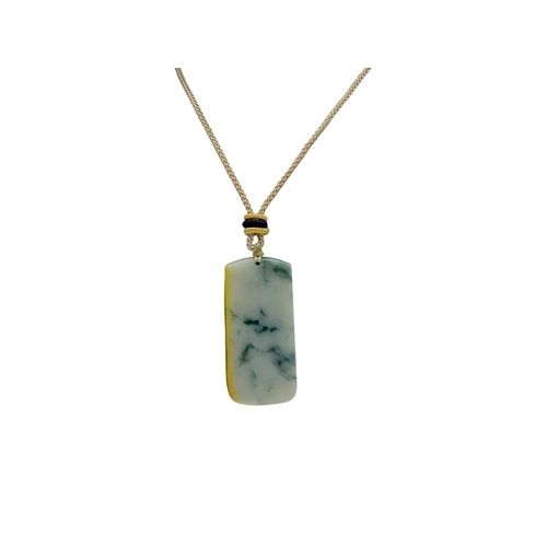 697 - A Jade Pendant Necklace.The stone shows contrasting pale celadon and darker green tones. Suspended f... 