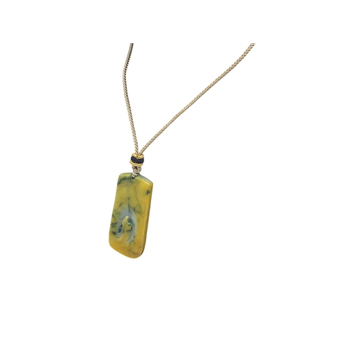697 - A Jade Pendant Necklace.The stone shows contrasting pale celadon and darker green tones. Suspended f... 