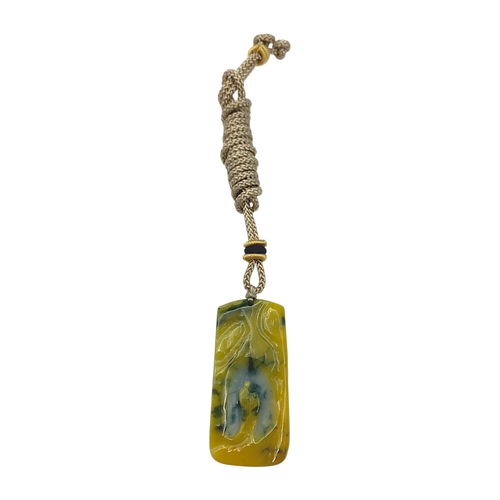697 - A Jade Pendant Necklace.The stone shows contrasting pale celadon and darker green tones. Suspended f... 