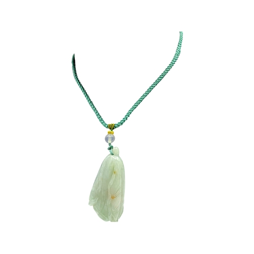 725 - A Jade Pendant Necklace. The celadon-green jade pendant finely carved in a flowing, organic form, su... 