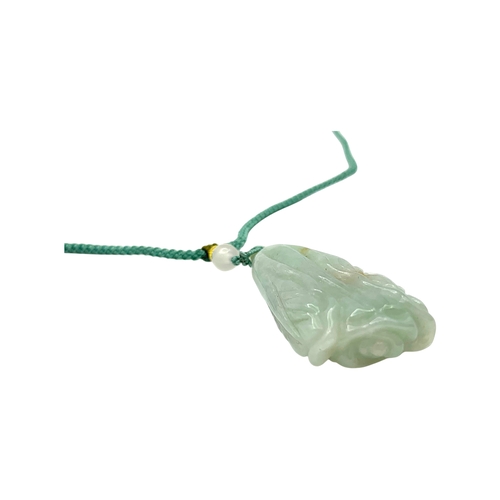 725 - A Jade Pendant Necklace. The celadon-green jade pendant finely carved in a flowing, organic form, su... 