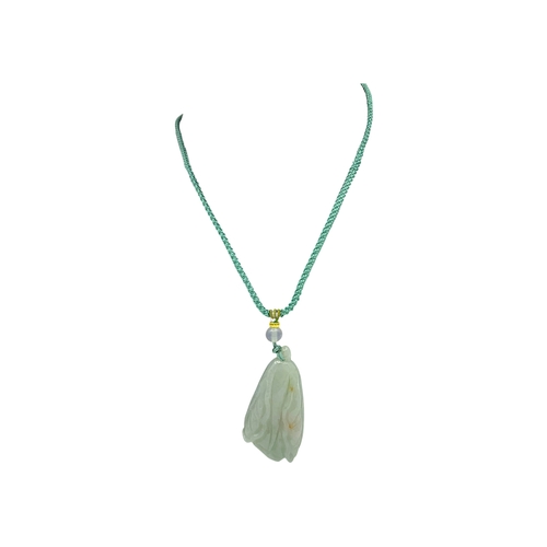 725 - A Jade Pendant Necklace. The celadon-green jade pendant finely carved in a flowing, organic form, su... 