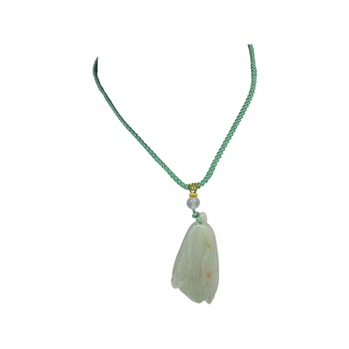 725 - A Jade Pendant Necklace. The celadon-green jade pendant finely carved in a flowing, organic form, su... 