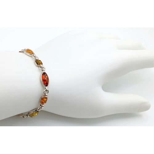 1260 - A Baltic Amber Multi-Colour Link Bracelet. Silver settings. Measured 20cm as flat. Never worn. Made ... 