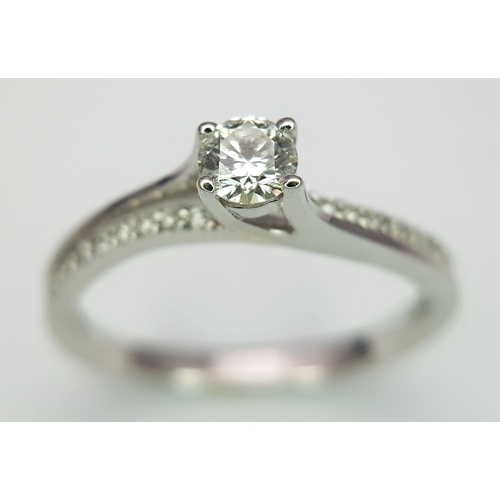 25 - An 18K White Gold Diamond Ring. A round brilliant cut 0.25ct diamond having G-H colour with VS2 clar... 