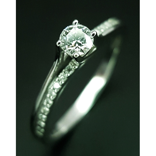 25 - An 18K White Gold Diamond Ring. A round brilliant cut 0.25ct diamond having G-H colour with VS2 clar... 