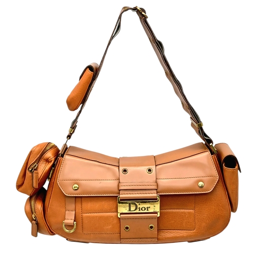 A Christian Dior Street Chic Columbus Shoulder Bag. Brown leather exterior with gold-tone hardware, wide adjustable shoulder strap with eyelet detailing, signature Dior plaque clasp, protective base studs, and magnetic flap closure. Dior monogram textile interior with a central compartment and a zipped inner side pocket. Features three small side pouches, one pouch to the strap, and an additional exterior side compartment. Approximately 36cm length x 14cm height x 9cm depth. In good vintage condition with some creasing, light surface wear, and scratches &ndash; please see photos or request a condition report. Ref: 27948