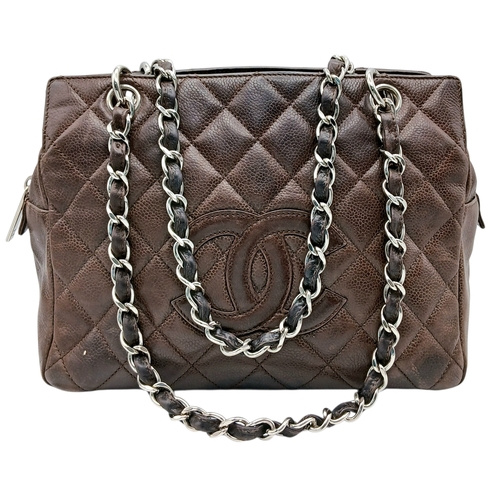 A Chanel Dark Brown Quilted Leather Shoulder Tote Bag. Brown leather exterior with silver-tone hardware, featuring chain and leather shoulder straps, protected base studs and zipped top closure. Brown textile interior with a main compartment, an opened side pocket and zipped side pocket. Some signs of wear, marks and scratches to the leather. Approx 25cm length x 19cm height x 13cm depth. Please see photos or request a condition report. Ref:27945.