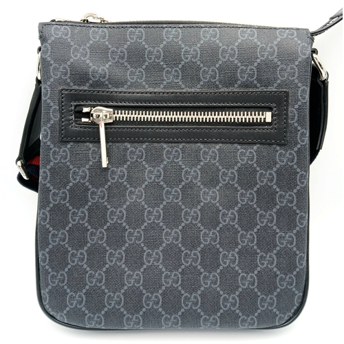 26 - A Black Gucci GG Canvas Web Stripe Crossbody Bag. Black GG monogram canvas exterior with silver-tone... 
