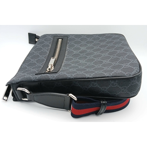 26 - A Black Gucci GG Canvas Web Stripe Crossbody Bag. Black GG monogram canvas exterior with silver-tone... 