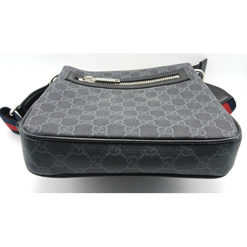 26 - A Black Gucci GG Canvas Web Stripe Crossbody Bag. Black GG monogram canvas exterior with silver-tone... 