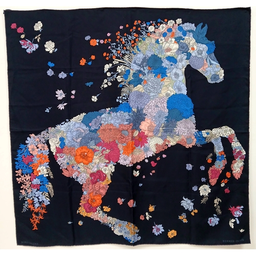 An Herm&egrave;s &ldquo;Robe L&eacute;g&egrave;re&rdquo; Carr&eacute; 90 Silk Scarf. Dark blue silk with multicoloured floral horse motif and hand-rolled edges. Approximate size: 89cm x 89cm. In good overall condition but Please see photos or request a condition report. Ref: 27847