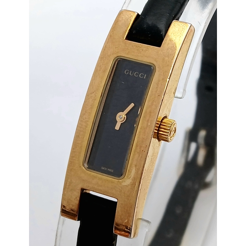 558 - A GUCCI, GOLD TONE, BLACK DIAL AND BLACK LEATHER STRAP WATCH. MODEL 3900L. IN FULL WORKING ORDER. S/... 