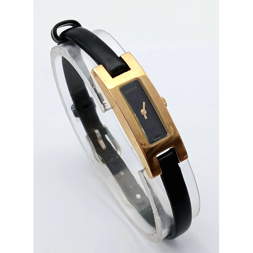 558 - A GUCCI, GOLD TONE, BLACK DIAL AND BLACK LEATHER STRAP WATCH. MODEL 3900L. IN FULL WORKING ORDER. S/... 