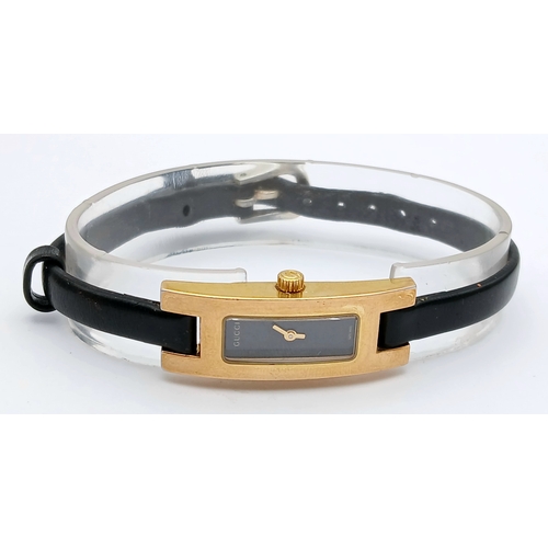 558 - A GUCCI, GOLD TONE, BLACK DIAL AND BLACK LEATHER STRAP WATCH. MODEL 3900L. IN FULL WORKING ORDER. S/... 