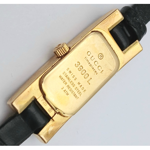 558 - A GUCCI, GOLD TONE, BLACK DIAL AND BLACK LEATHER STRAP WATCH. MODEL 3900L. IN FULL WORKING ORDER. S/... 