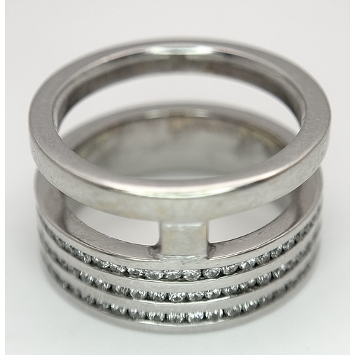 507 - An 18K White Gold and Diamond Band Ring. A split band with three channel set diamond full eternity r... 
