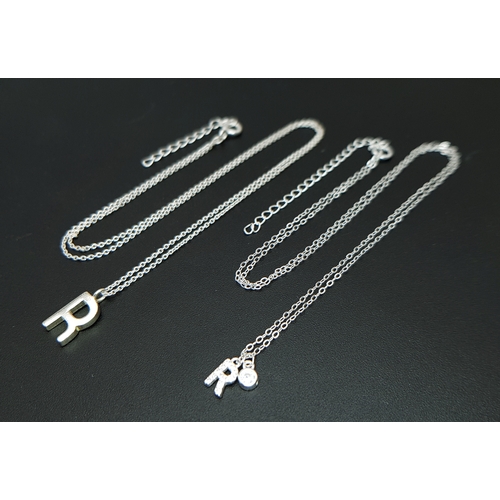 1203 - A PAIR OF STERLING SILVER NECKLACES WITH INITIAL R PENDANTS. ONE IS STONE SET. TOTAL WEIGHT 2.6G. A/... 