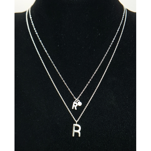 1203 - A PAIR OF STERLING SILVER NECKLACES WITH INITIAL R PENDANTS. ONE IS STONE SET. TOTAL WEIGHT 2.6G. A/... 