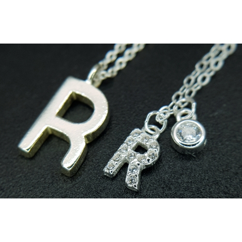 1203 - A PAIR OF STERLING SILVER NECKLACES WITH INITIAL R PENDANTS. ONE IS STONE SET. TOTAL WEIGHT 2.6G. A/... 