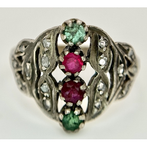 122 - An Antique Gold, Silver, Ruby and Emerald Ring. The band tests as 14k gold with an openwork silver s... 