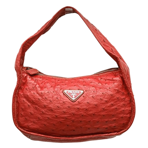 124 - A Red Prada Ostrich Effect Leather Crossbody Bag. Red ostrich effect leather exterior with silver-to... 