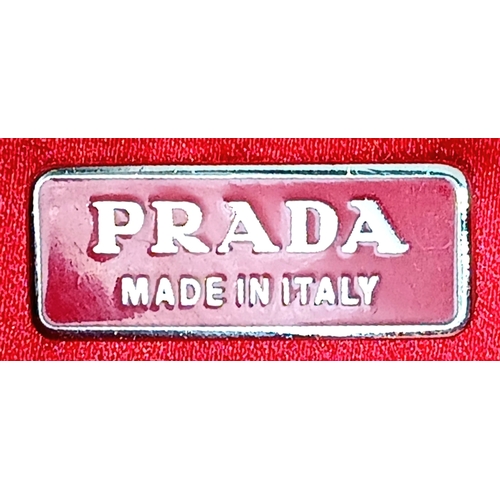 124 - A Red Prada Ostrich Effect Leather Crossbody Bag. Red ostrich effect leather exterior with silver-to... 