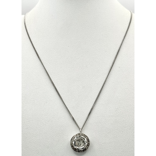 137 - A Platinum 0.5ct Centre Diamond Halo Pendant on a 9K White Gold Chain Necklace. The Centre Diamond o... 