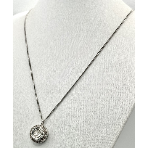 137 - A Platinum 0.5ct Centre Diamond Halo Pendant on a 9K White Gold Chain Necklace. The Centre Diamond o... 