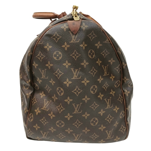 138 - A Brown Louis Vuitton Monogram Keepall 60 Travel Bag. Brown monogram coated canvas exterior with vac... 