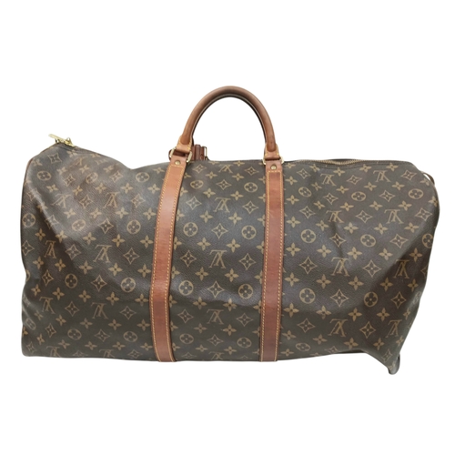 138 - A Brown Louis Vuitton Monogram Keepall 60 Travel Bag. Brown monogram coated canvas exterior with vac... 