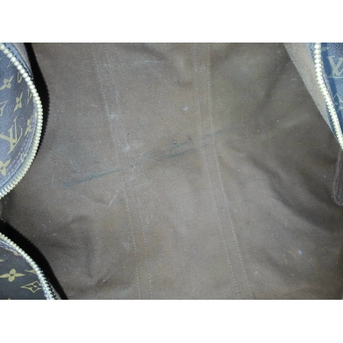 138 - A Brown Louis Vuitton Monogram Keepall 60 Travel Bag. Brown monogram coated canvas exterior with vac... 