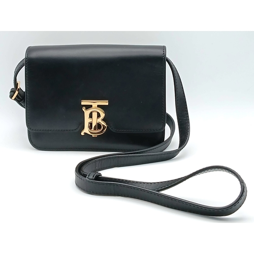 159 - A Burberry Black Leather TB Crossbody Bag. Smooth black leather exterior with gold-tone hardware, ad... 
