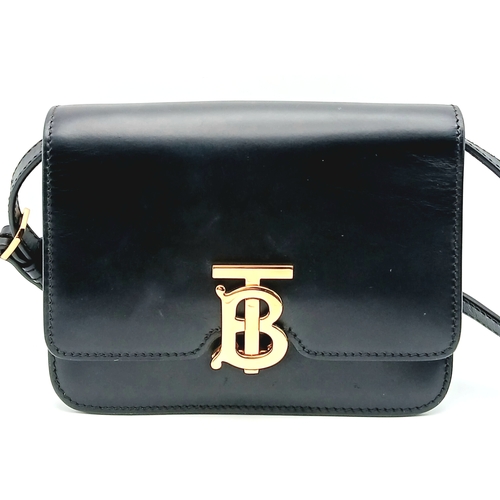 159 - A Burberry Black Leather TB Crossbody Bag. Smooth black leather exterior with gold-tone hardware, ad... 