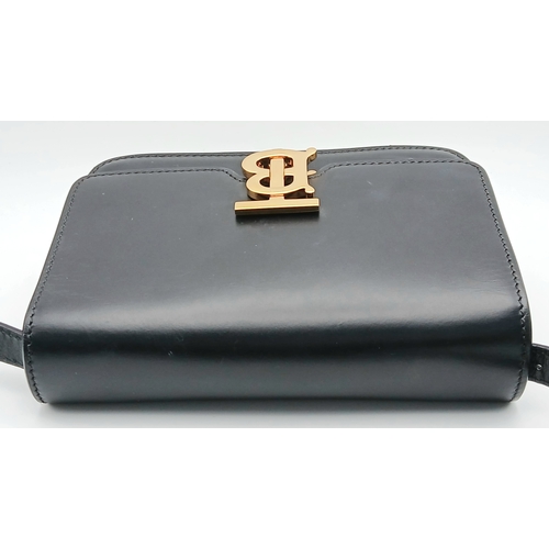 159 - A Burberry Black Leather TB Crossbody Bag. Smooth black leather exterior with gold-tone hardware, ad... 