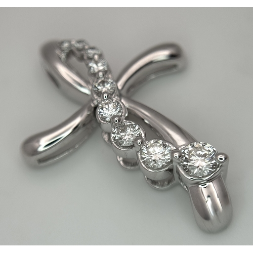 241 - A 14K White Gold Diamond Cross Pendant. c.0.60ctw of round brilliant cut diamonds having G-H colour ... 