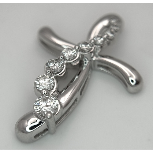 241 - A 14K White Gold Diamond Cross Pendant. c.0.60ctw of round brilliant cut diamonds having G-H colour ... 