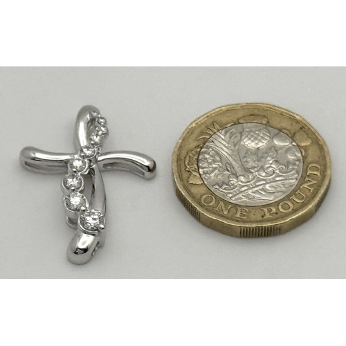 241 - A 14K White Gold Diamond Cross Pendant. c.0.60ctw of round brilliant cut diamonds having G-H colour ... 
