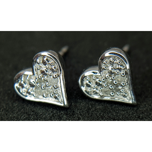 566 - A PAIR OF 9K WHITE GOLD, DIAMOND SET, HEART SHAPED STUD EARRINGS. 1.3G. NEEDS BUTTERFLY BACKS.  SC 1... 