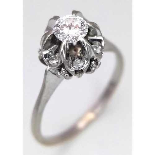 1213 - An 18K White Gold Diamond Cluster Ring. A 0.25ct round brilliant cut centre stone with a 0.20ctw dia... 