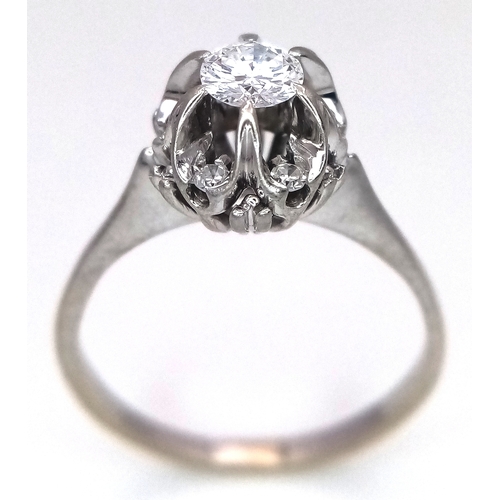 1213 - An 18K White Gold Diamond Cluster Ring. A 0.25ct round brilliant cut centre stone with a 0.20ctw dia... 