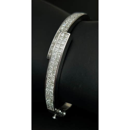 32 - A Sophisticated 18K White Gold and Diamond Crossover Bangle Bracelet. Eighty-Four Princess cut chann... 