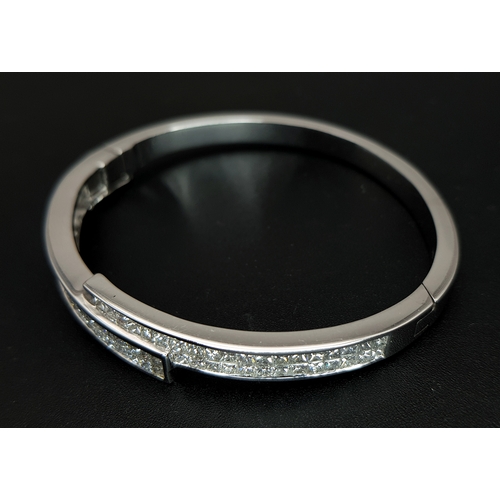 32 - A Sophisticated 18K White Gold and Diamond Crossover Bangle Bracelet. Eighty-Four Princess cut chann... 