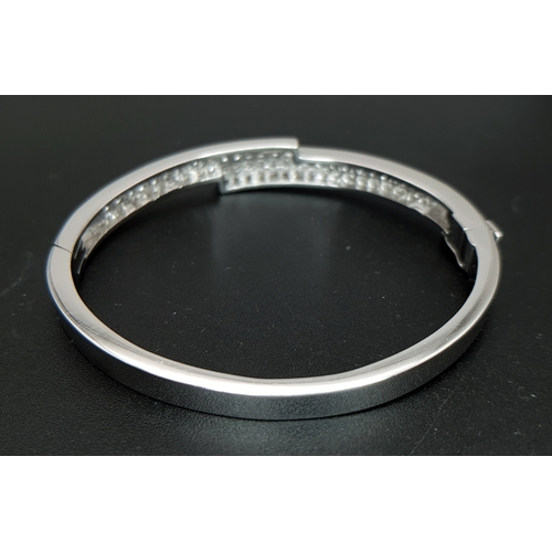 32 - A Sophisticated 18K White Gold and Diamond Crossover Bangle Bracelet. Eighty-Four Princess cut chann... 