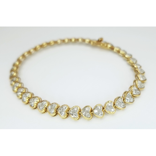 11 - An 18K Yellow Gold Diamond Tennis Bracelet in Heart-Shaped Links. Over 100 round brilliant cut diamo... 